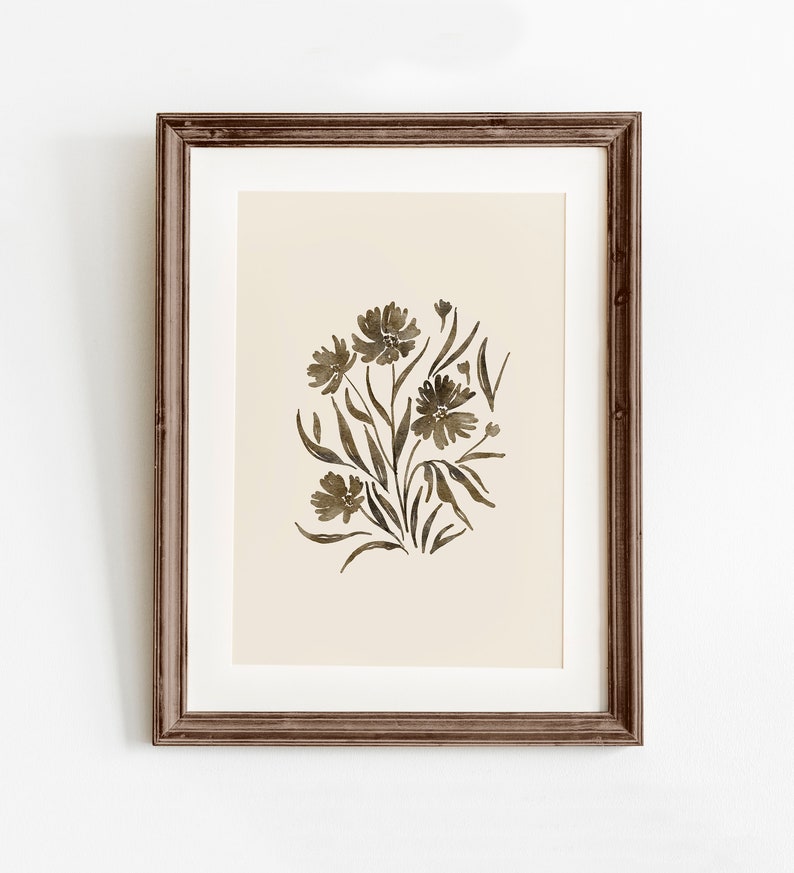 May include: A framed print of a watercolor painting of a bouquet of brown flowers with green leaves on a beige background.