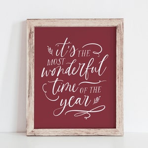 May include: A framed print with a red background and white text that reads "It's the most wonderful time of the year".