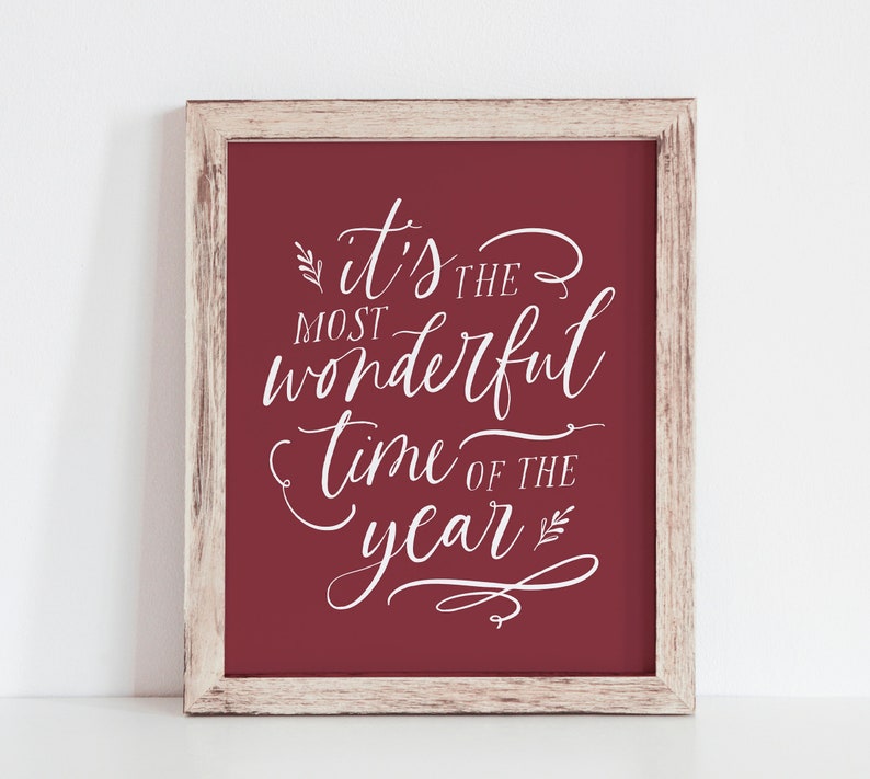 May include: A framed print with a red background and white text that reads "It's the most wonderful time of the year".