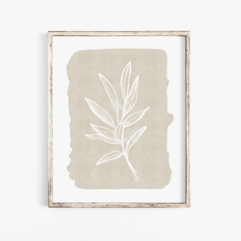May include: A framed print featuring a white line drawing of a leafy branch on a beige background.