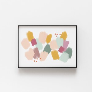 May include: Abstract art print with a black frame. The print features a colorful design of overlapping shapes in shades of pink, yellow, green, and brown.