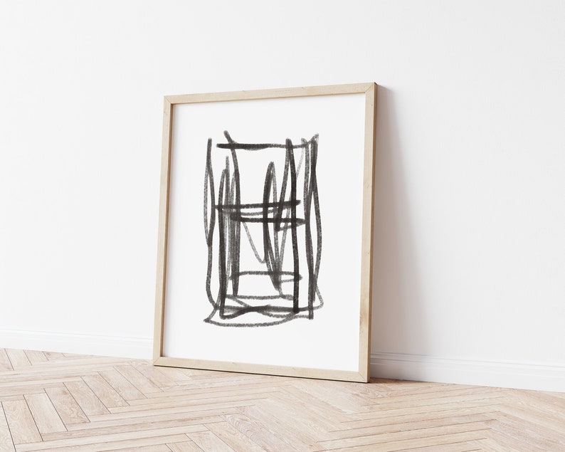 May include: A black and white abstract drawing in a wooden frame. The drawing features a series of intersecting lines and shapes.