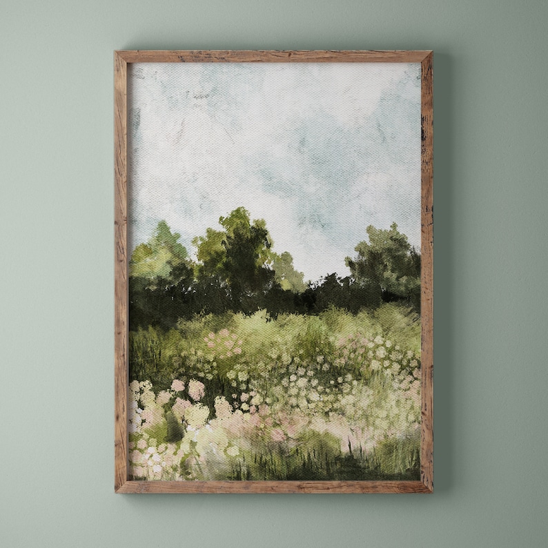 Puede incluir: Una pintura de acuarela enmarcada de un paisaje con un campo de flores blancas en primer plano y una l&iacute;nea de &aacute;rboles en el fondo. El cielo es de un azul claro con algunas nubes.