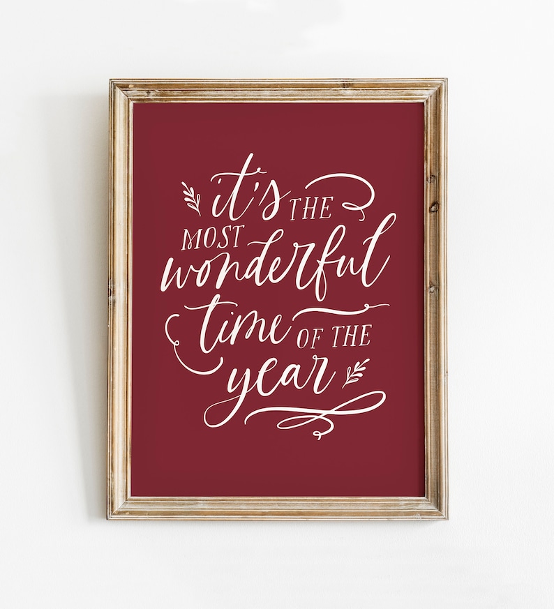 May include: A framed print with a red background and white text that reads "it's the most wonderful time of the year".