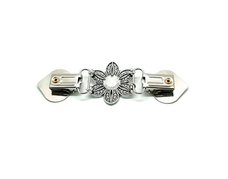 K&ouml;nnte beinhalten: Silberfarbener Metallverschluss mit floraler Mitte und zwei herzf&ouml;rmigen Endst&uuml;cken. Der Verschluss hat ein filigranes Blumendesign mit einem zentralen, klaren Stein. Zum Befestigen von Kleidungsst&uuml;cken oder Accessoires.