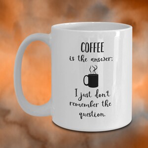 May include: White ceramic coffee mug with black text that reads "COFFEE is the answer; I just don't remember the question."