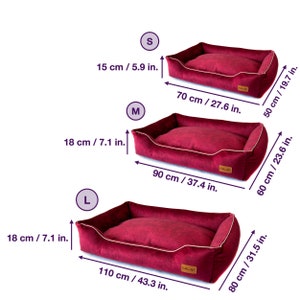 K&ouml;nnte beinhalten: Drei bordeauxfarbene Hundebetten in verschiedenen Gr&ouml;&szlig;en: klein (70 cm lang), mittel (90 cm lang) und gro&szlig; (110 cm lang). Jedes Bett hat eine wei&szlig;e Umrandung und eine rechteckige Form, mit Ma&szlig;en in cm und Zoll.
