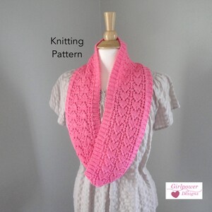 May include: A bright pink knitted infinity scarf with a textured pattern, displayed on a mannequin. The scarf is made of soft yarn and features a repeating design. The words "Knitting Pattern" are visible in the image.