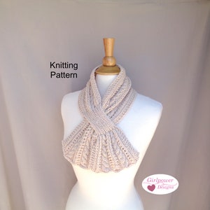 May include: Knitting pattern for a beige cowl neck scarf. The scarf is displayed on a white mannequin. The text "Knitting Pattern" is visible at the top of the image. The text "Girlpower Designs" is visible at the bottom of the image.