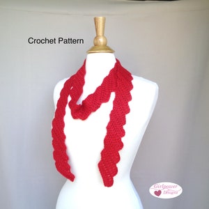 May include: A red crocheted scarf with a scalloped edge. The scarf is draped over a white mannequin. The text "Crochet Pattern" is visible at the top of the image. The text "Girlpower Designs" is visible at the bottom of the image.