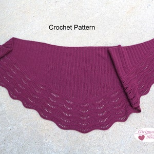 May include: A burgundy crochet shawl with a scalloped edge and a delicate lace pattern. The shawl is folded in half and laid flat on a concrete surface. The text "Crochet Pattern" is visible at the top of the image. The text "Girlpower Designs" is visible at the bottom of the image.