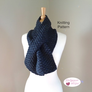 Może przedstawiać: Granatowy, dziany szal w kształcie ósemki na białym manekinie. Szal wykonany jest z fakturowanego splotu. Tekst "Knitting Pattern" znajduje się nad szalem, a "Girlpower Designs" pod szalem.