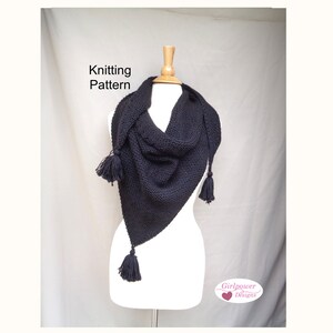 May include: Black knitted triangular scarf with tassels on a white mannequin. The scarf is made with a simple stitch pattern and has a relaxed drape. The text "Knitting Pattern" is visible at the top of the image.