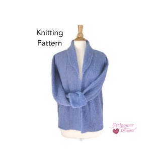 May include: A light blue knitted cardigan displayed on a mannequin. The cardigan has a shawl collar and is tied at the waist. The words "Knitting Pattern" are printed on the upper left. The Girlpower Designs logo is on the lower right.