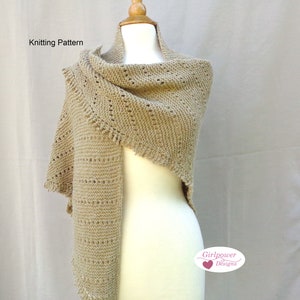 May include: A beige knitted shawl with a delicate lace pattern. The shawl is draped over a white dress form. The text "Girlpower Designs" is visible in the lower right corner of the image.