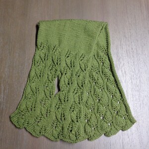 Pode incluir: Uma echarpe de malha verde com um padr&atilde;o de folhas.