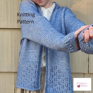 May include: A light blue knitted cardigan with a leaf pattern on the lower front. The sleeves have a thumb hole design. The words "Knitting Pattern" are visible on the left side of the image. The cardigan is worn over a white shirt and a plaid skirt.