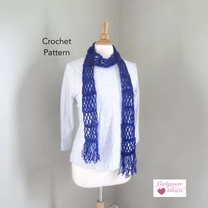 May include: A royal blue crochet scarf with fringe on a white striped shirt mannequin. The text "Crochet Pattern" is above the mannequin and "Girlpower Designs" is below the mannequin.
