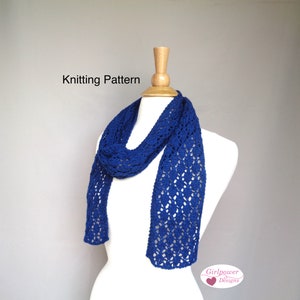 May include: A royal blue knitted scarf with a lacy pattern. The scarf is draped over a white mannequin. The text "Knitting Pattern" is at the top of the image. The text "Girlpower Designs" is at the bottom of the image.