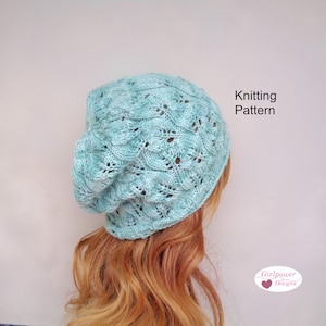 May include: A light blue knitted hat with a lacy pattern. The hat is being worn by a person with long, red hair. The text "Knitting Pattern" and "Girlpower Designs" is visible in the image.