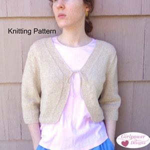 Könnte beinhalten: Strickanleitung für eine beige, verkürzte Strickjacke mit Bindeband vorne. Die Strickjacke wird über einem rosa T-Shirt getragen.