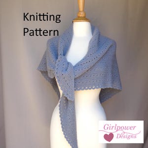 May include: A light blue knitted shawl displayed on a mannequin. The shawl has a decorative edge and is tied in the front. The words "Knitting Pattern" are visible on the left side of the image. The Girlpower Designs logo is on the right.