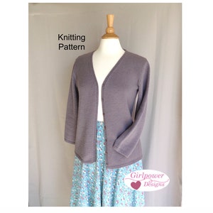 May include: A gray knitted cardigan with a v-neck and long sleeves. The cardigan is on a mannequin and is displayed against a white background. The text "Knitting Pattern" is at the top of the image. The text "Girlpower Designs" is at the bottom of the image.