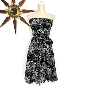 May include: A strapless black and white polka dot dress with a fitted bodice and a flowing skirt.