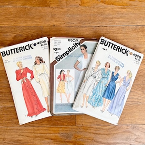 May include: Three vintage sewing patterns for dresses. The patterns are from Butterick and Simplicity. The Butterick patterns are for sizes 8-10 and 12-14. The Simplicity pattern is for size 12. The patterns feature illustrations of women wearing the dresses.