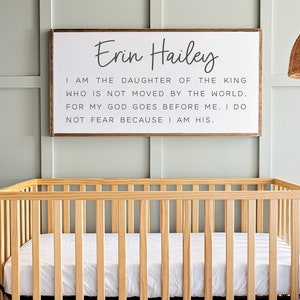 Może przedstawiać: Drewniane ł&oacute;żeczko z białym materacem i tabliczką nad nim, na kt&oacute;rej napisano: "Erin Hailey Jestem c&oacute;rką kr&oacute;la, kt&oacute;ry nie jest poruszany przez świat. Bo m&oacute;j B&oacute;g idzie przede mną. Nie boję się, bo jestem jego."