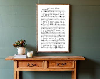 May include: A wooden console table with two drawers and a framed print of a hymn sheet titled "Turn Your Eyes upon Jesus". The table is in front of a green wall with white horizontal planks.