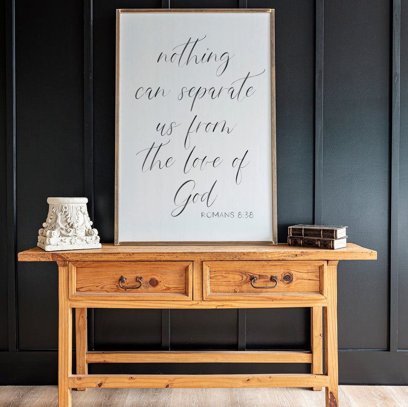 May include: A wooden console table with two drawers and a framed print with the text "nothing can separate us from the love of God ROMANS 8:38".
