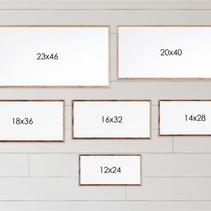May include: A wall display of six different sized wood picture frames with white mats. The frames are arranged in a staggered pattern. The frames are labeled with their dimensions in inches: 23x46, 20x40, 18x36, 16x32, 14x28, and 12x24.