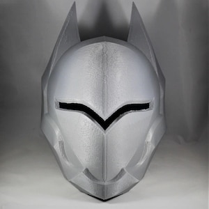 May include: A 3D printed gray helmet with a pointed top and a black visor. The helmet has a detailed design with sharp angles and edges.