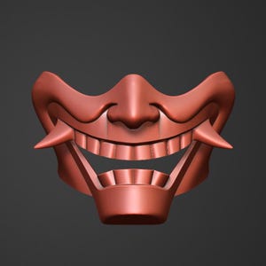 May include: A red, detailed, plastic mask with a wide, toothy grin. The mask has a sharp, pointed nose and a wide, open mouth.