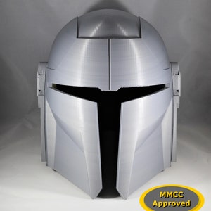 May include: A 3D printed white helmet with a black visor and a yellow oval sticker that says "MMCC Approved".