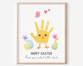 Puede incluir: Una impresión de arte de huella de mano de pollito amarillo con el texto "Feliz Pascua" y "De tu pollito más lindo". El pollito está rodeado de huevos de Pascua y flores coloridos.