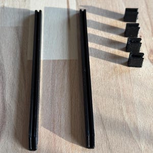 May include: Two black metal rods with threaded ends and four black plastic connectors.