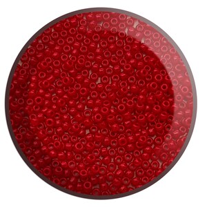 May include: A close-up view of a large quantity of small, round, red beads. The beads are arranged in a circular pattern and appear to be made of glass.