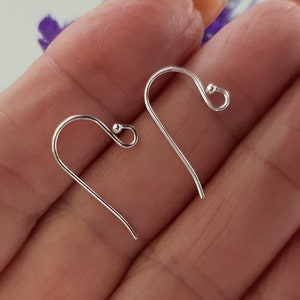 May include: Two silver earring hooks with a small ball at the end of each hook.