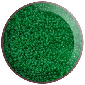 May include: A close-up view of a large quantity of small, round, opaque green beads. The beads are arranged in a circular pattern, creating a visually appealing and uniform texture.