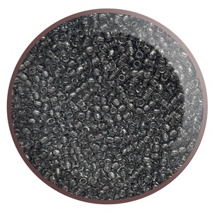 May include: A close-up image of a large quantity of small, round, silver-coloured beads. The beads are arranged in a circular pattern and appear to be made of glass or plastic.