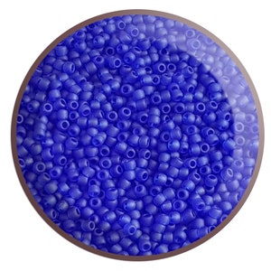 May include: A close-up view of a bowl filled with small, round, opaque blue beads. The beads are uniform in size and have a smooth, slightly glossy finish.