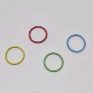 May include: Four thin, circular rings in distinct colors are arranged on a plain surface. The set includes one red ring, one light blue ring, one yellow ring, and one green ring. Each ring features a small, visible seam where the ends meet.