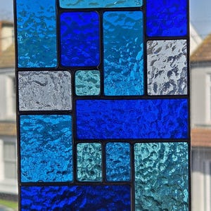 Vitrail attrape-soleil abstrait géométrique en panneau de vitrail dans des tons de bleu fait main en Angleterre