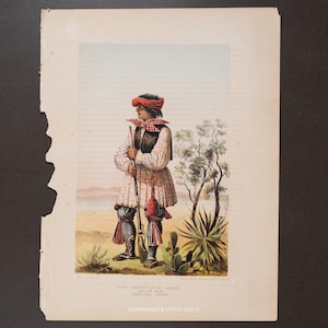 May include: A vintage print depicting a figure in traditional attire, holding a rifle. The figure wears a red turban, a patterned tunic, and knee-high boots. The background shows a desert landscape with sparse vegetation. Text at the bottom reads "ENGRAVINGS & LITHOS 2025 ©".
