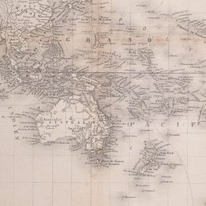 Puede incluir: Un mapa de papel de estilo antiguo que muestra el océano Pacífico, Australia y el sudeste asiático. El mapa presenta etiquetas geográficas en francés, incluyendo nombres de islas, archipiélagos y regiones costeras, con una cuadrícula de latitud y longitud.