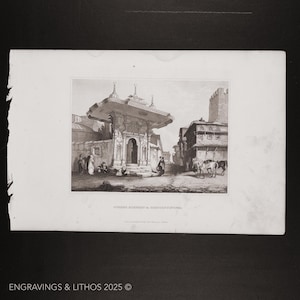 May include: A black and white engraving of a fountain in Constantinople, Turkey. The fountain is a domed structure with a central archway and is surrounded by buildings and people.