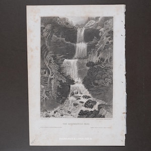 May include: A black and white antique engraving titled THE CATTERSKILL FALL, depicting a multi-tiered waterfall cascading down rocky cliffs surrounded by trees. The print features detailed shading and text at the bottom, with aged paper edges.