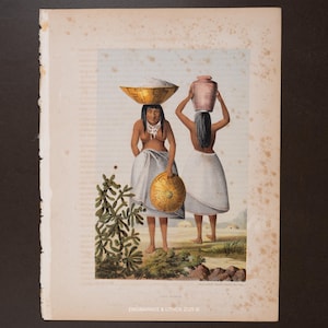 Puede incluir: Grabado antiguo que representa a dos mujeres llevando objetos sobre sus cabezas. Una equilibra un cuenco dorado, la otra una jarra de terracota. Las mujeres visten faldas blancas y están en un paisaje. El grabado está sobre papel envejecido.